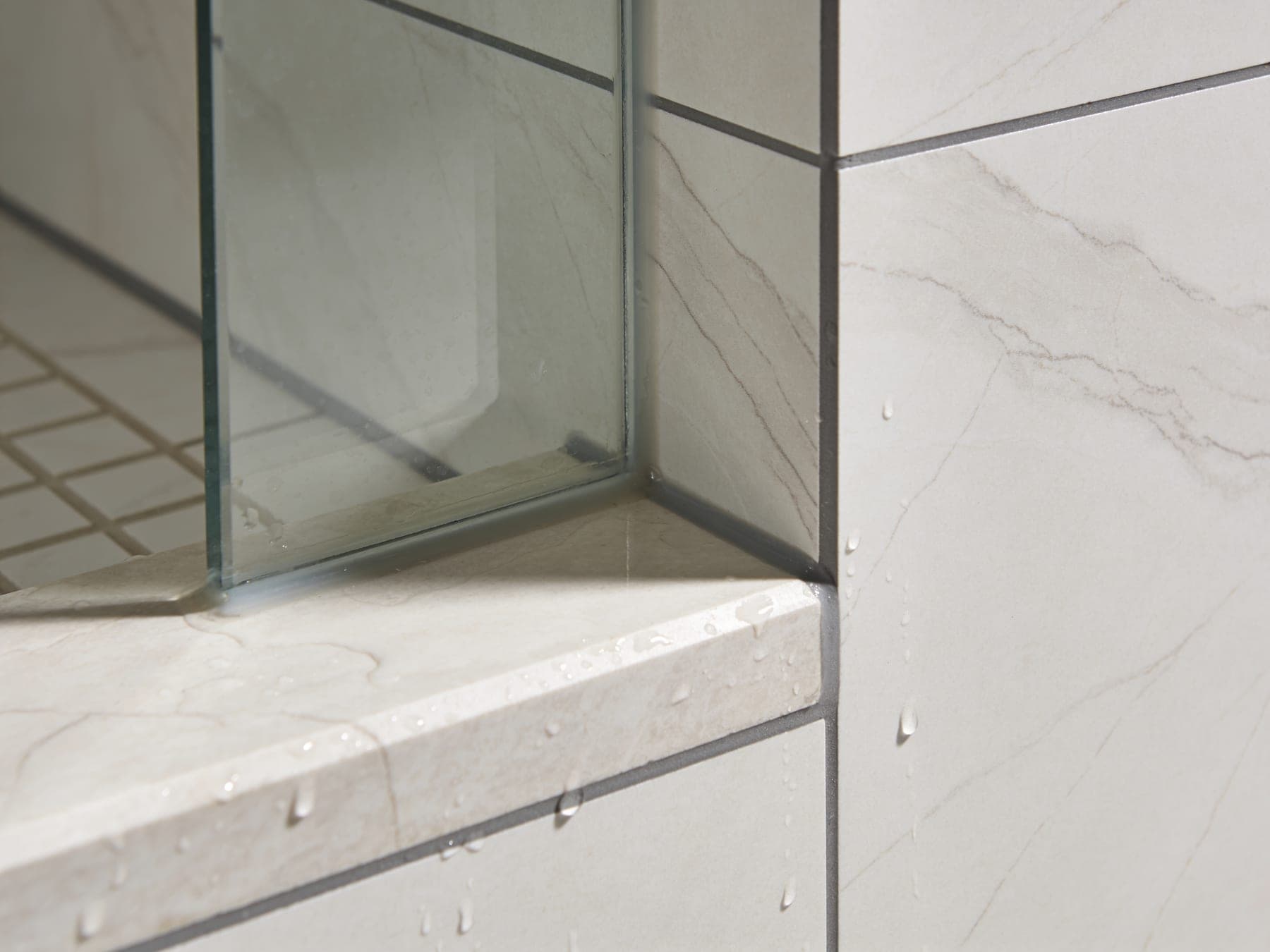 Close up of a 45 degree mitred porcelain corner on a shower curb