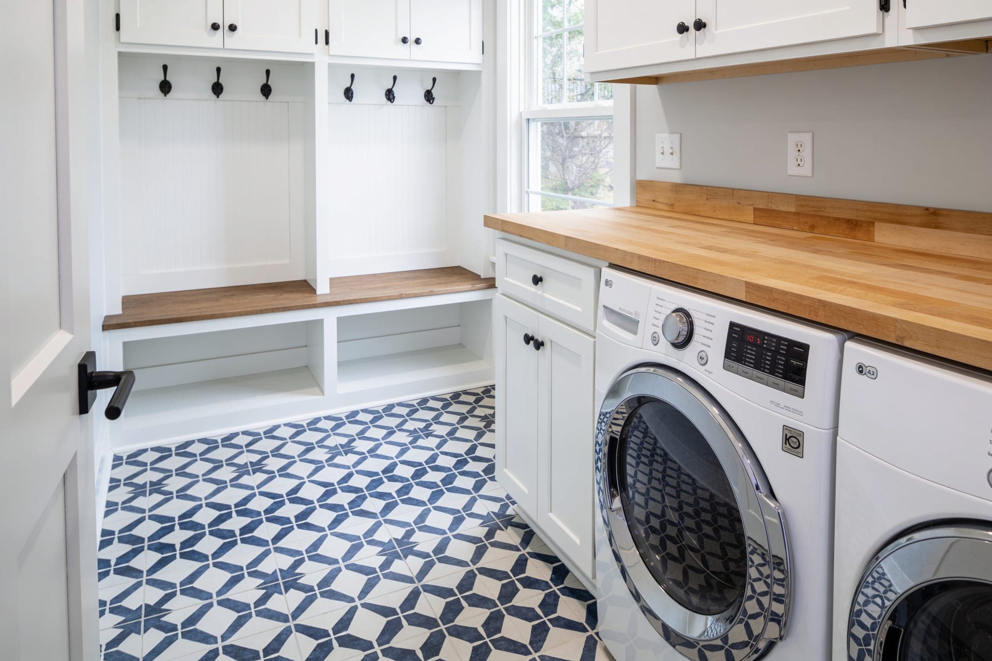 Laundry room with navy and white patterned encaustic-look porcelain floor